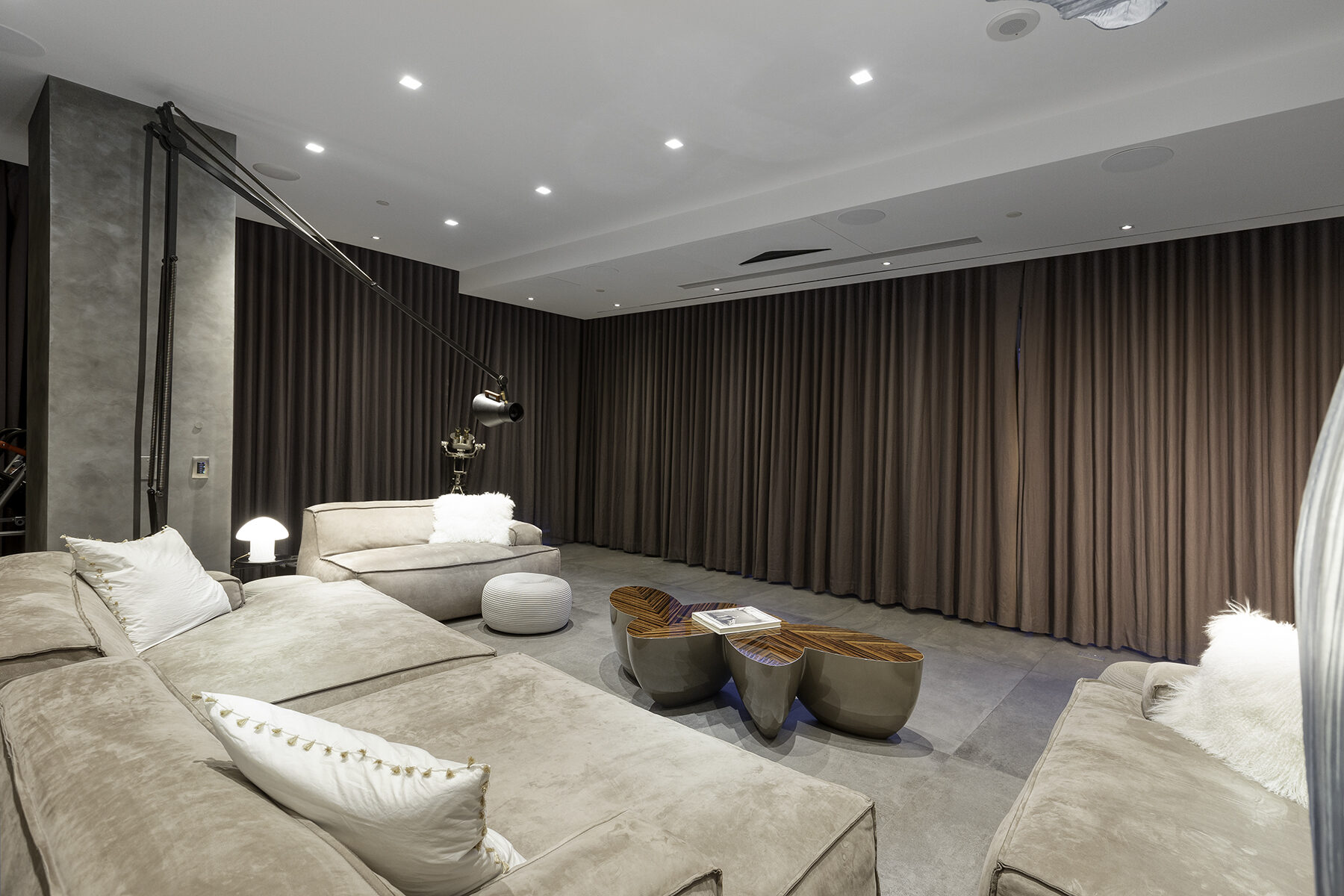 The same room in full theater mode with the floor to ceiling curtains drawn closed for blackout