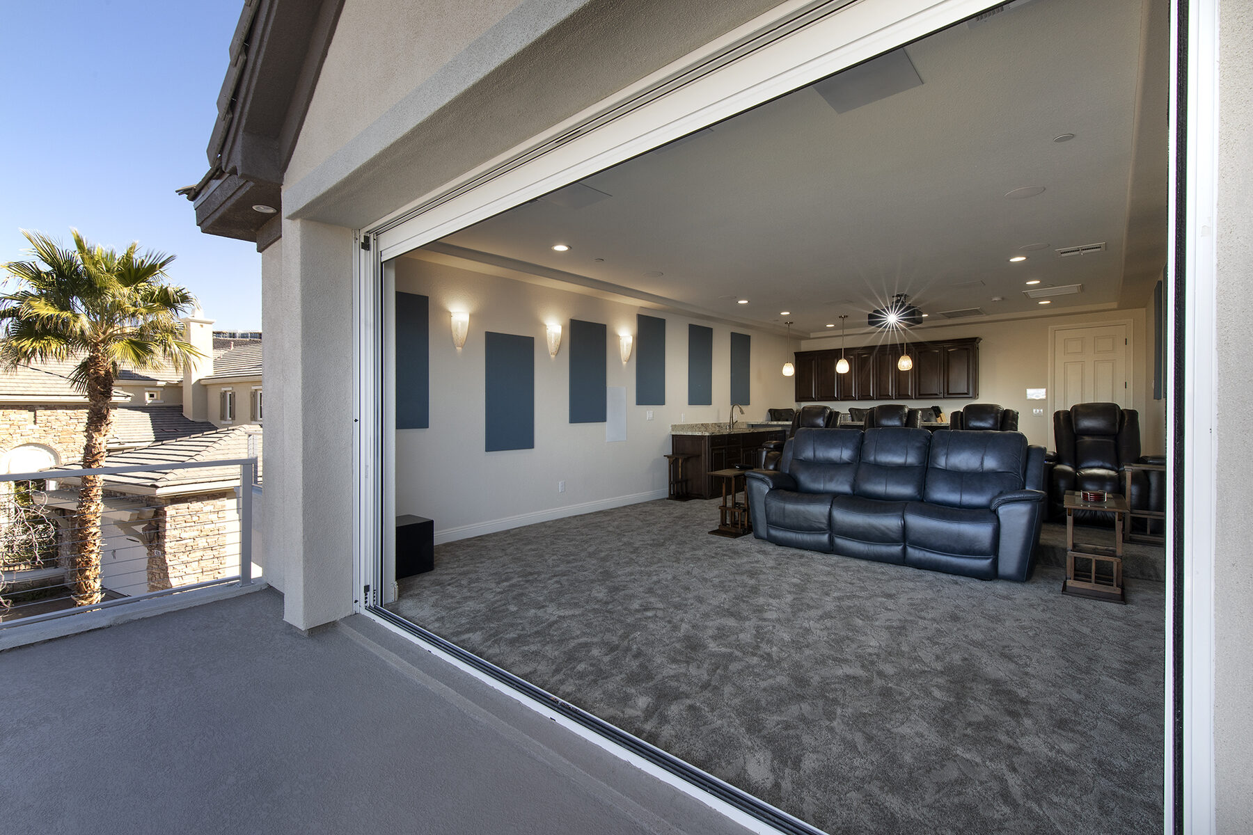The reveal: the pocket slider behind the screen wall opened, looking into the theater from the patio