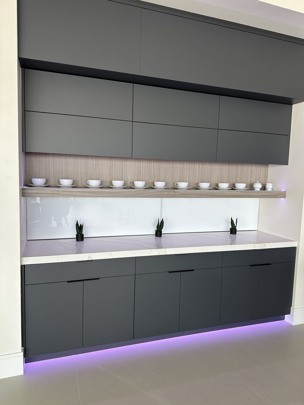 Butler's pantry with backlit shelving and accent lighting beneath the cabinetry