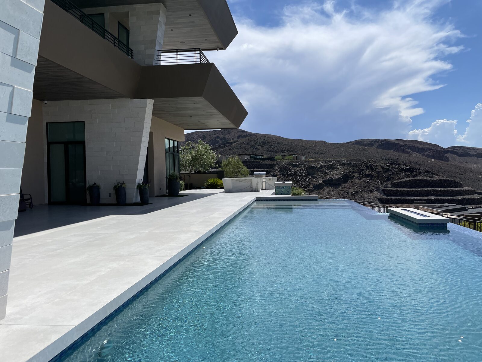 Infinity pool running along the house with open desert and mountains beyond
