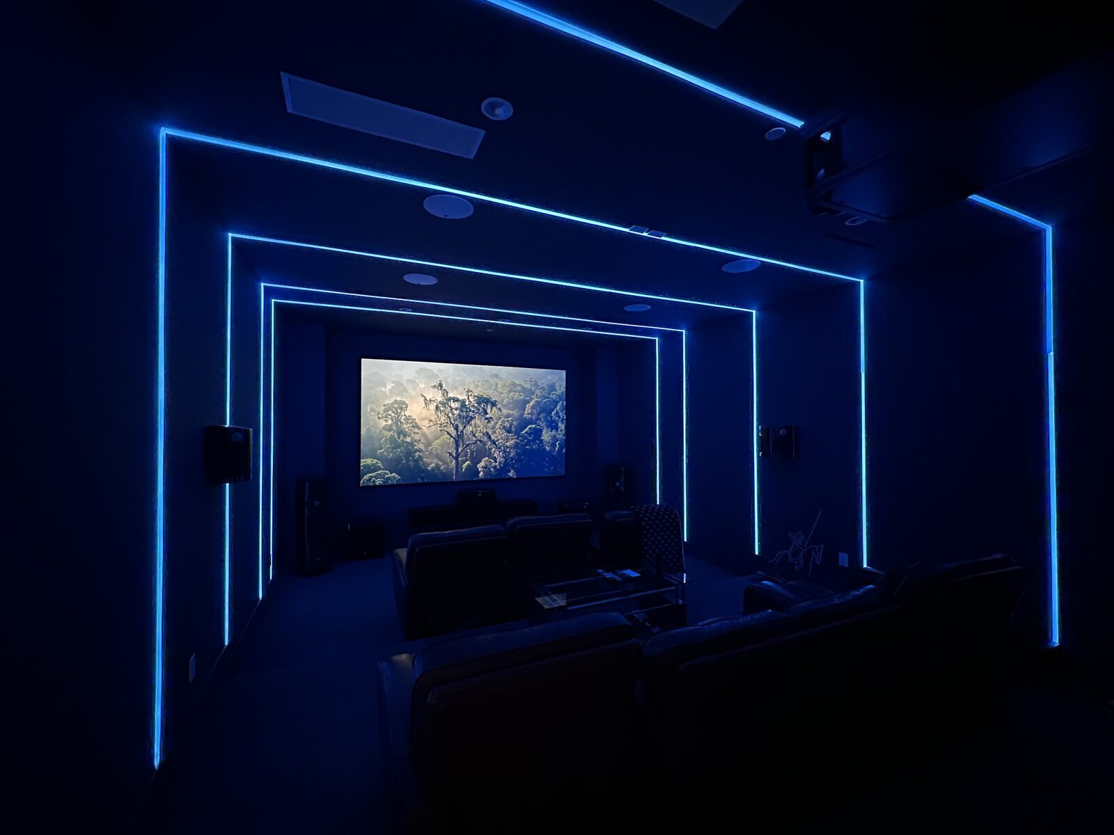 Private theater with colour-changing perimeter lighting outlining the walls and ceiling